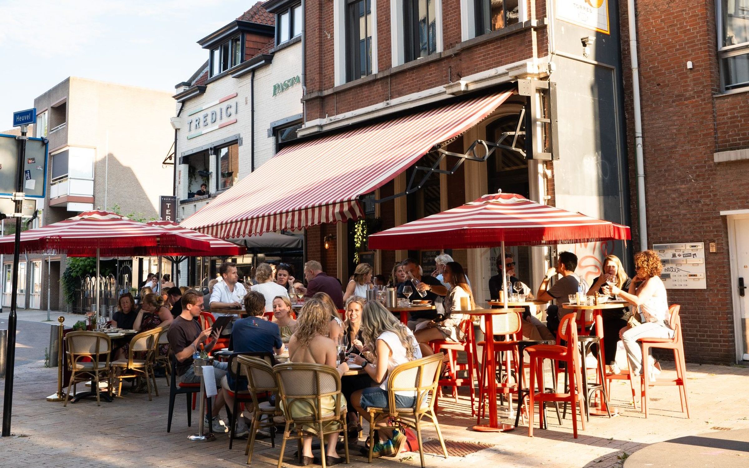 Het terras van Hooked op de Korte Heuvel in Tilburg, onder rood-wit gestreepte luifels